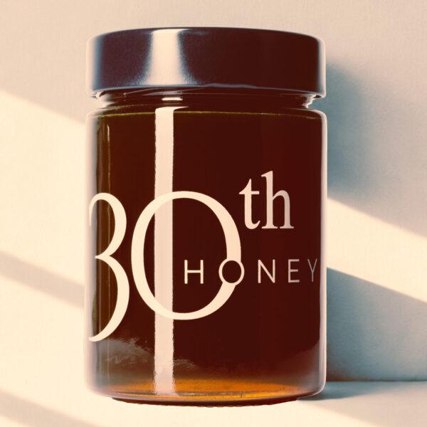 pot en verre de miel multiflores naturel pur 100% à la texture liquide ambrée.