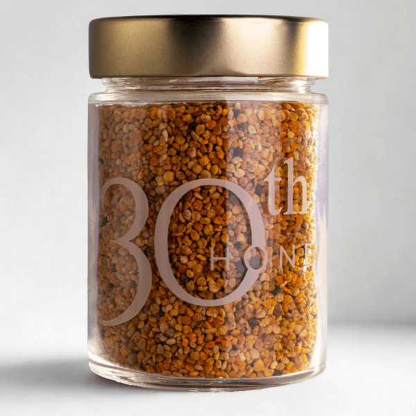 Pot en verre contenant du pollen d'abeille multicolore naturel en granulés.